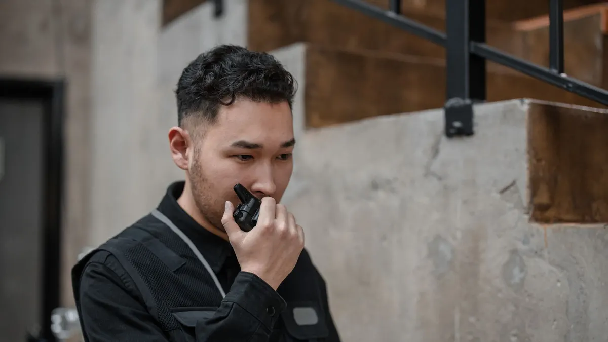 Security officer speaking into a two-way radio at a commercial building